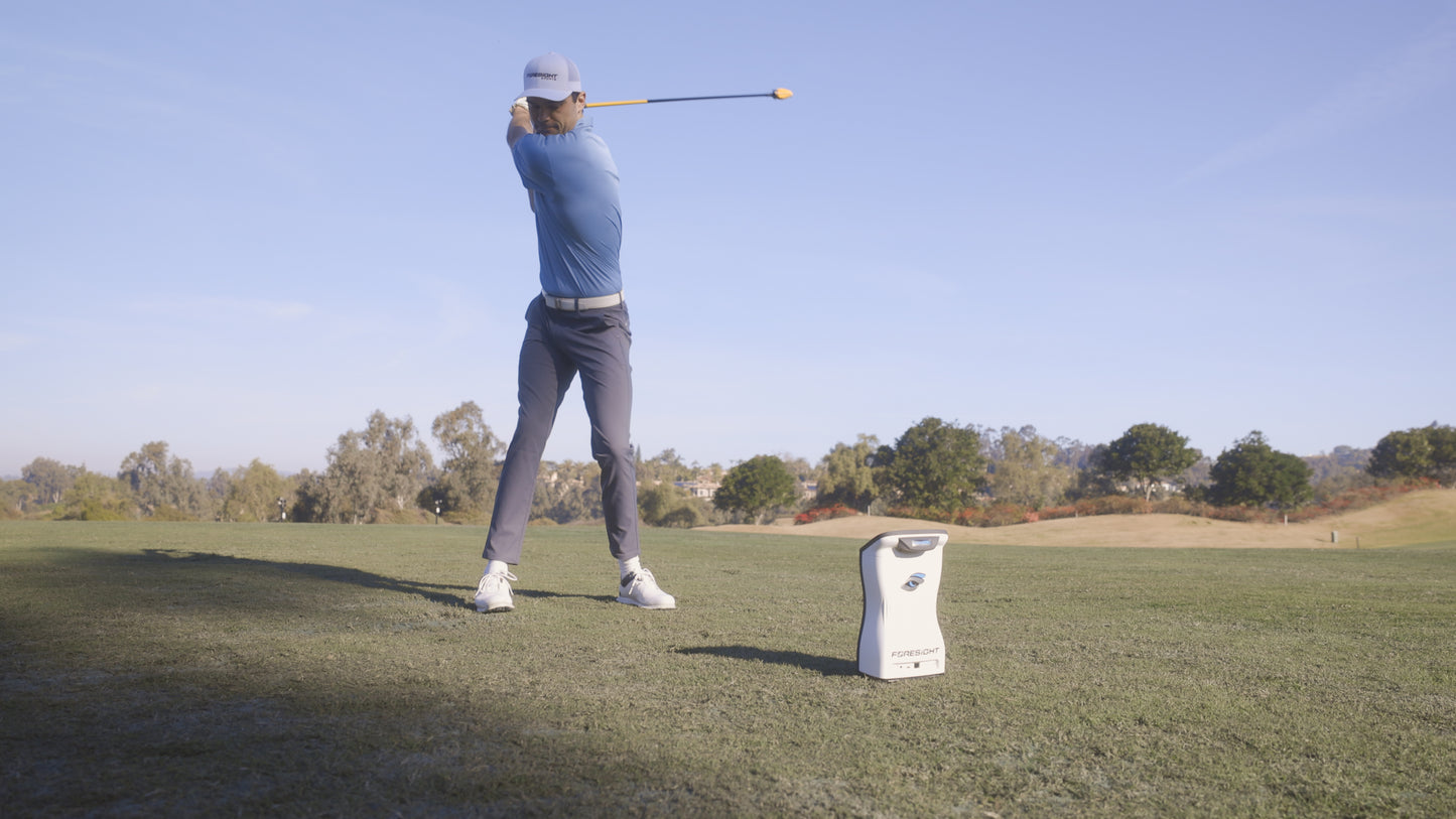 Golfer On Range Using QuadMax Swing Speed Trainer